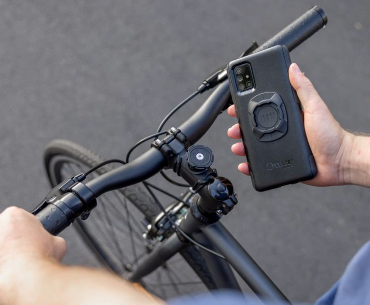 Quadlock Universal Adapter monterad på ett mobilskal och fäst på en cykelstyre. Perfekt för säker smartphone-användning vid cykling.